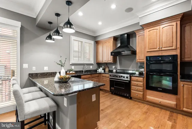 a kitchen with granite countertop a stove sink and refrigerator