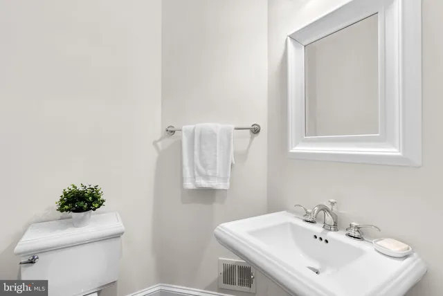 a bathroom with a sink a toilet and mirror