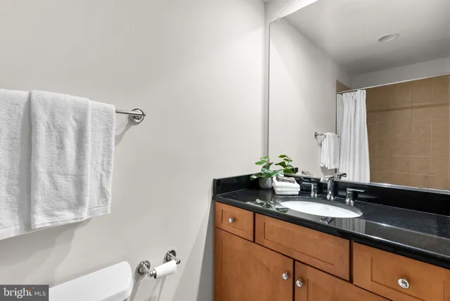 a bathroom with a granite countertop sink and a mirror
