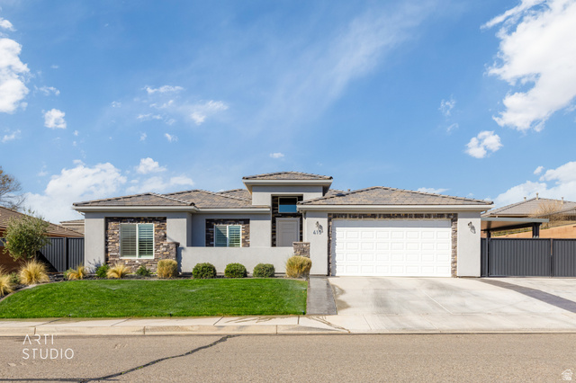 415 North 2750 East St. George, UT 84790 - Photo 1 of 1 Prairie-style house featuring stone siding, stucco siding, an attached garage, and concrete driveway