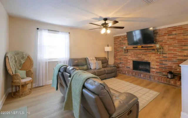 a living room with furniture a flat screen tv and a fireplace