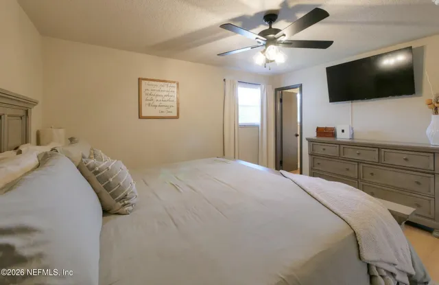 a bedroom with a large bed and a flat screen tv