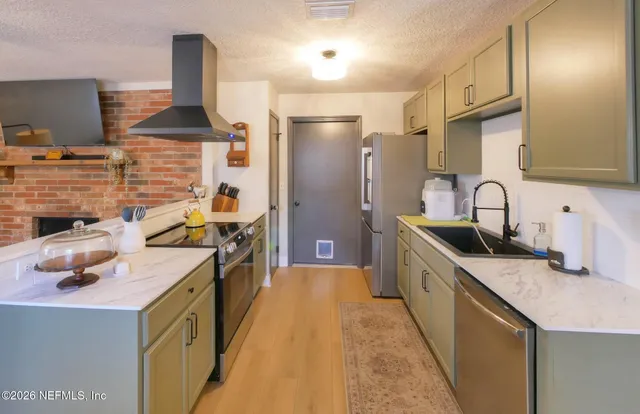 a kitchen with stainless steel appliances a sink stove and refrigerator