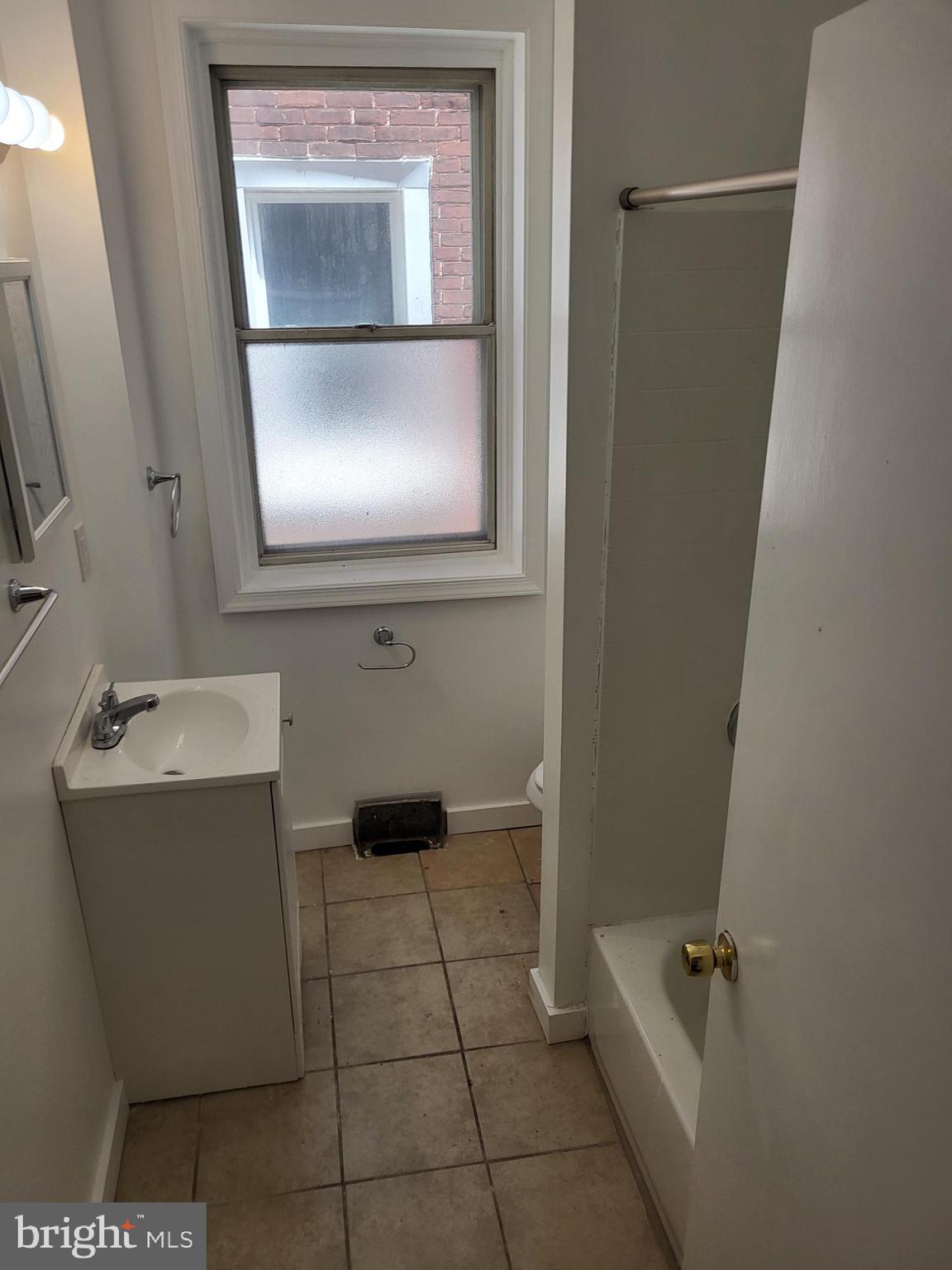 4834 Sansom Street, Unit 1 Philadelphia, PA 19139 - Photo 12 of 23 a bathroom with a granite countertop sink a mirror and a bathtub