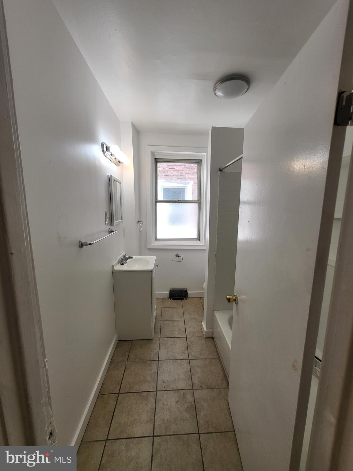 4834 Sansom Street, Unit 1 Philadelphia, PA 19139 - Photo 14 of 23 a bathroom with a sink a toilet and window
