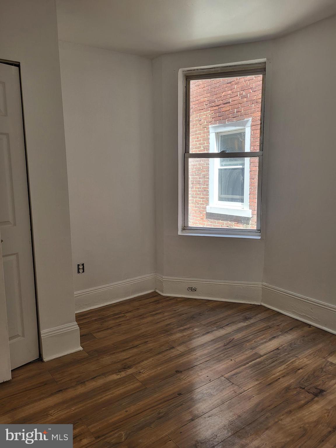 4834 Sansom Street, Unit 1 Philadelphia, PA 19139 - Photo 16 of 23 an empty room with wooden floor and windows