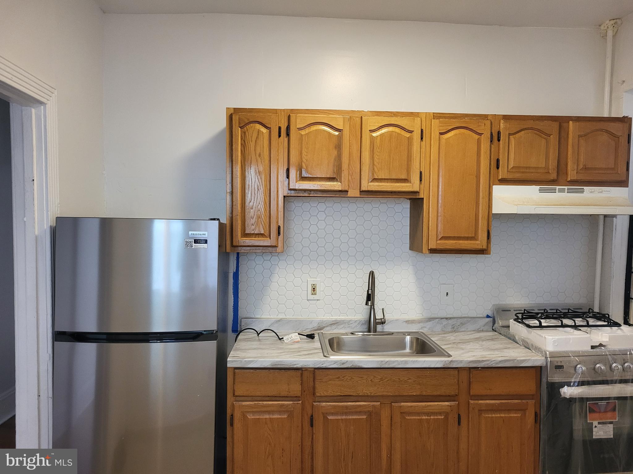 4834 Sansom Street, Unit 1 Philadelphia, PA 19139 - Photo 18 of 23 a kitchen with a refrigerator and a sink