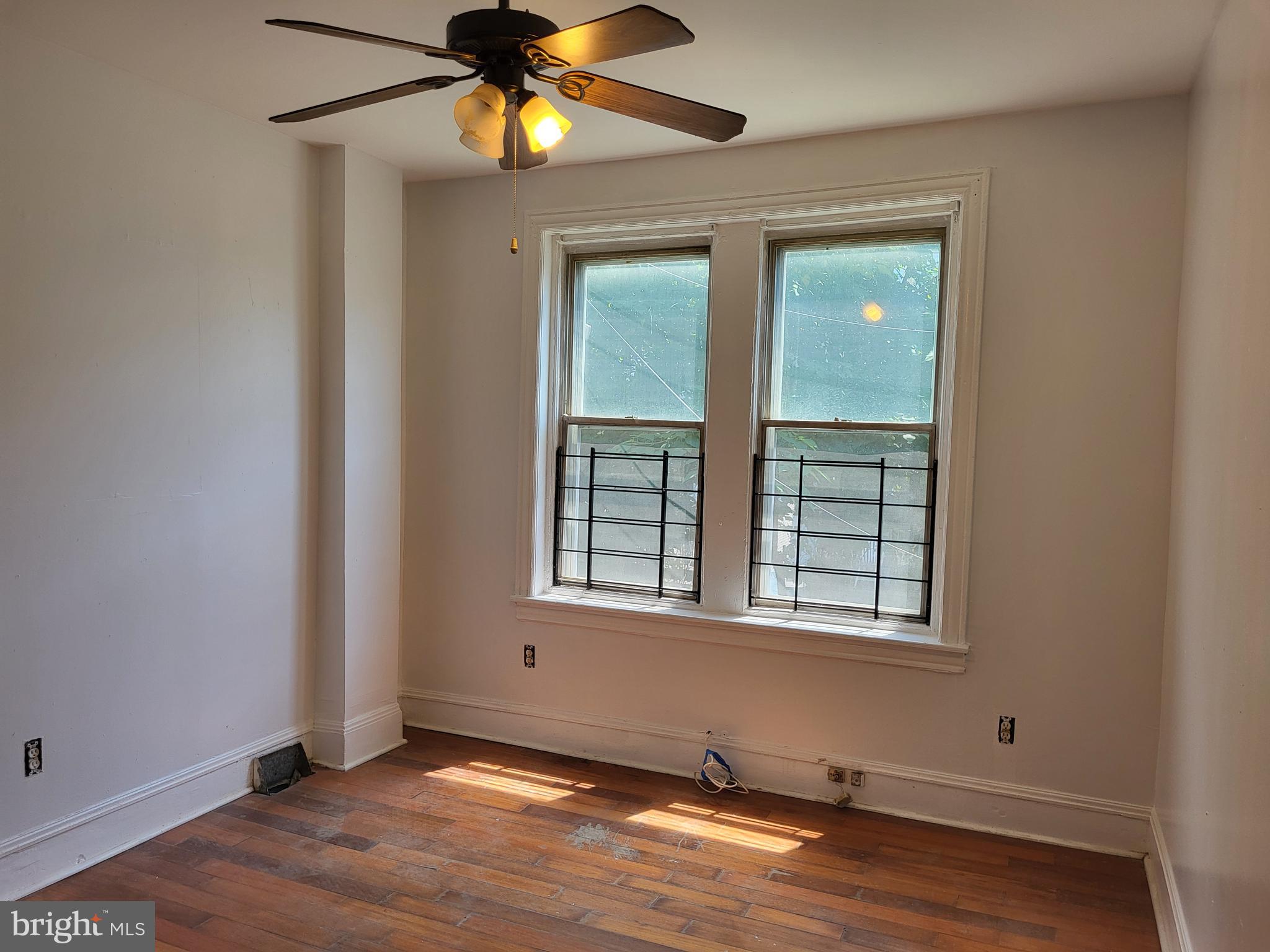 4834 Sansom Street, Unit 1 Philadelphia, PA 19139 - Photo 20 of 23 an empty room with wooden floor closet and windows