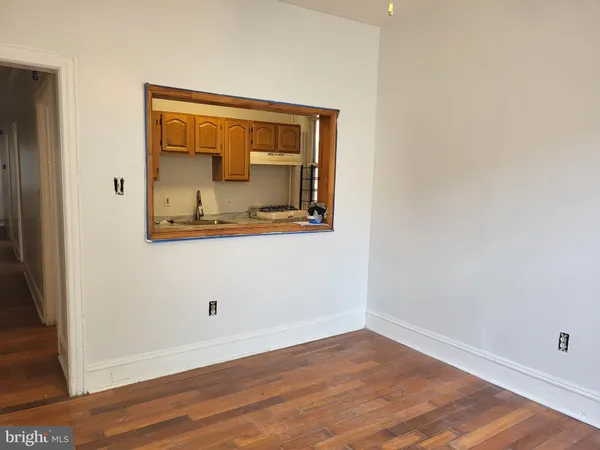 an empty room with wooden floor and mirror