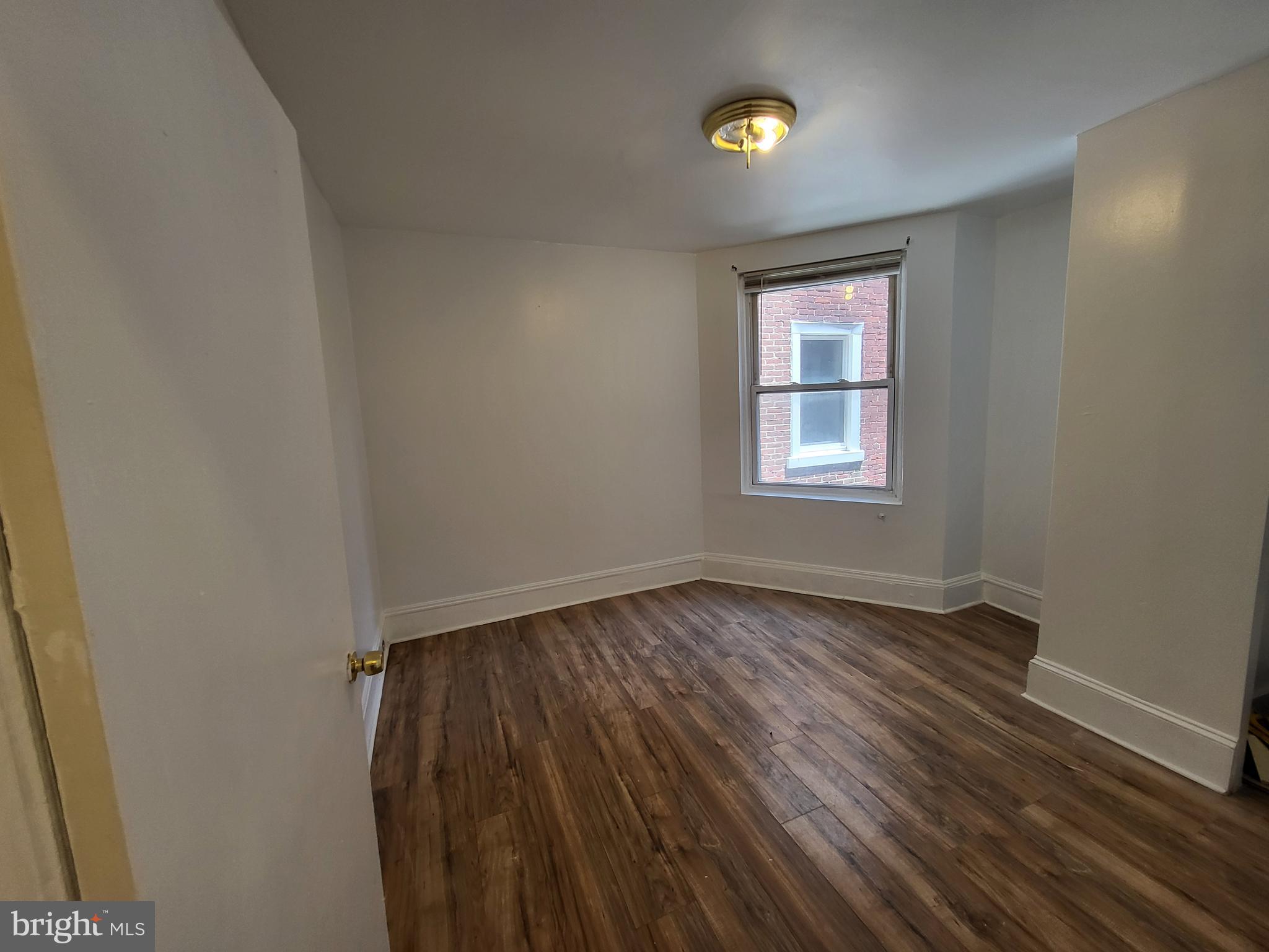4834 Sansom Street, Unit 1 Philadelphia, PA 19139 - Photo 8 of 23 wooden floor in an empty room with a window