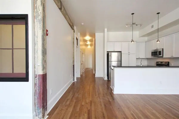 a view of a kitchen with wooden floor and a window