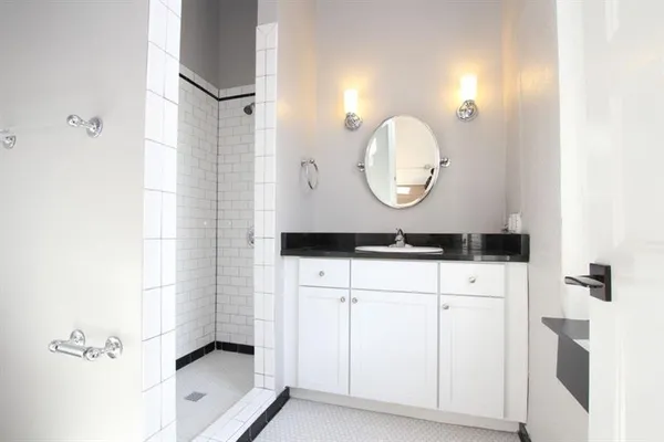 a bathroom with a sink mirror and a shower