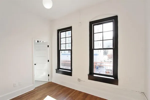 an empty room with windows and closet