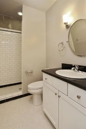 a bathroom with a sink a toilet and shower