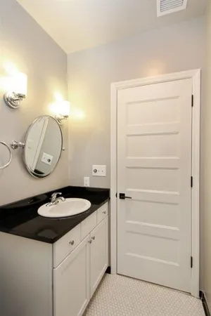 a bathroom with a granite countertop sink and a mirror
