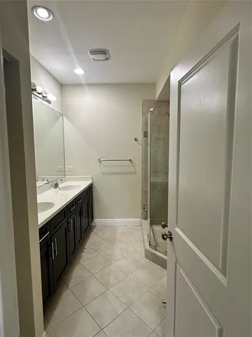 a bathroom with a double vanity sink a mirror and a shower