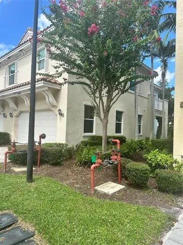a front view of a house with a yard and potted plants