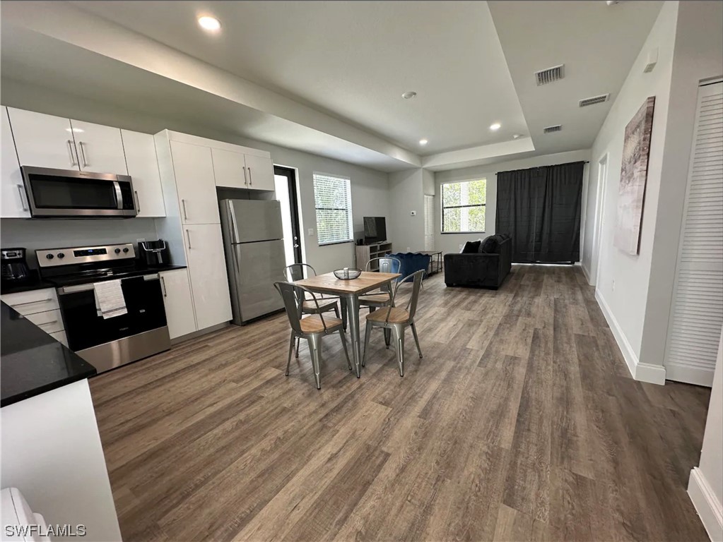 a living room with furniture and a wooden floor