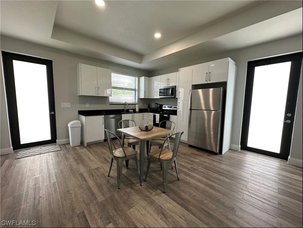 3027 North Lakewood Road LaBelle, FL 33935 - Photo 2 of 5 a kitchen with stainless steel appliances a dining table chairs refrigerator and sink