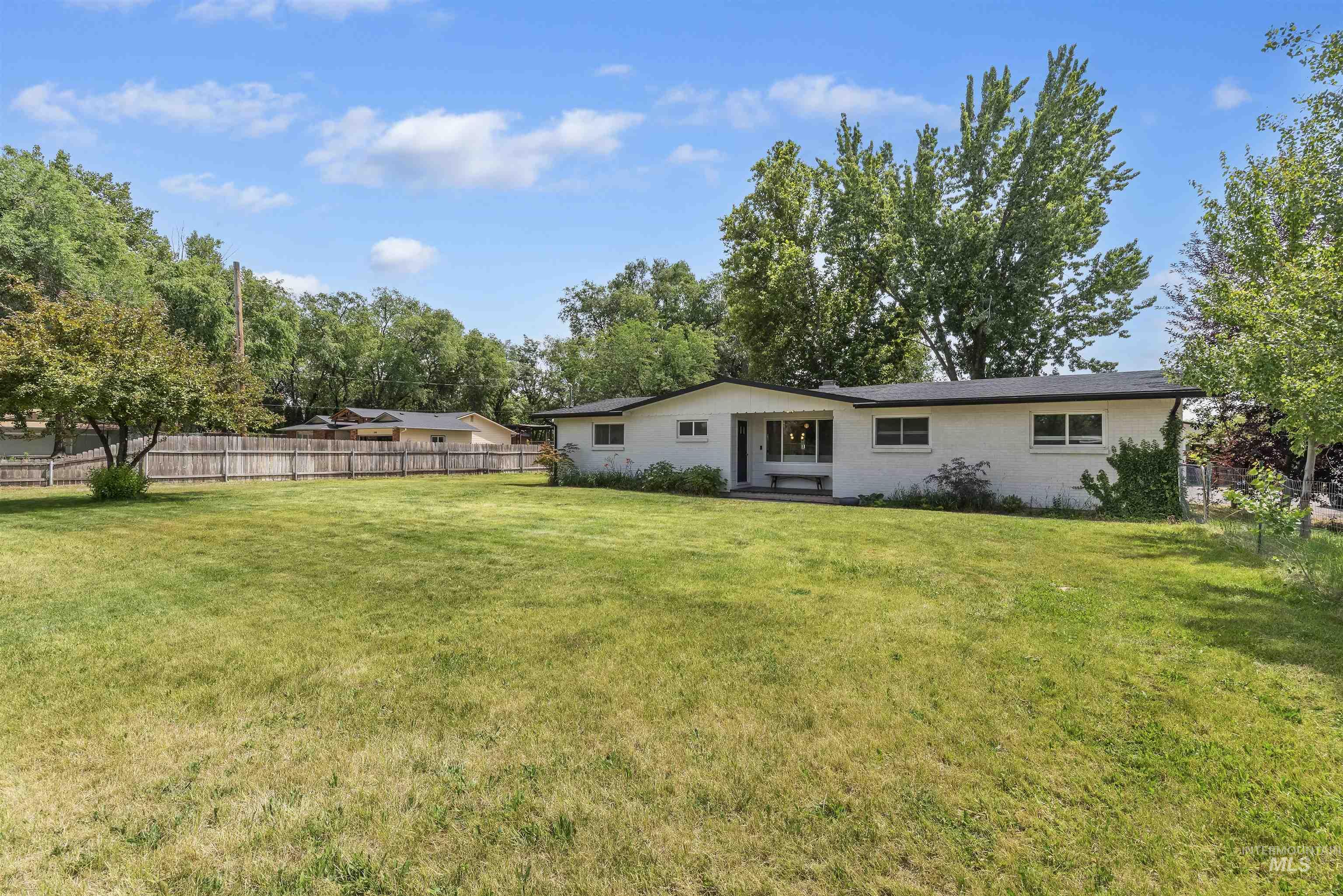355 East Beacon Light Road Eagle, ID 83616 - Photo 2 of 47 White exterior residence with a dark roof and multiple windows