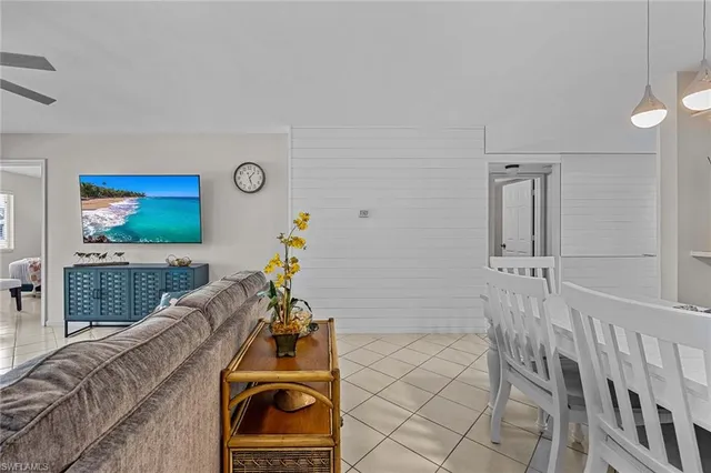 a living room with furniture a flat screen tv and a large window