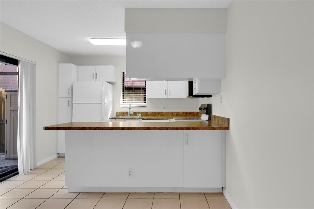 7801 Courtyard Run West Boca Raton, FL 33433 - Photo 11 of 31 a kitchen with stainless steel appliances granite countertop a sink and white cabinets