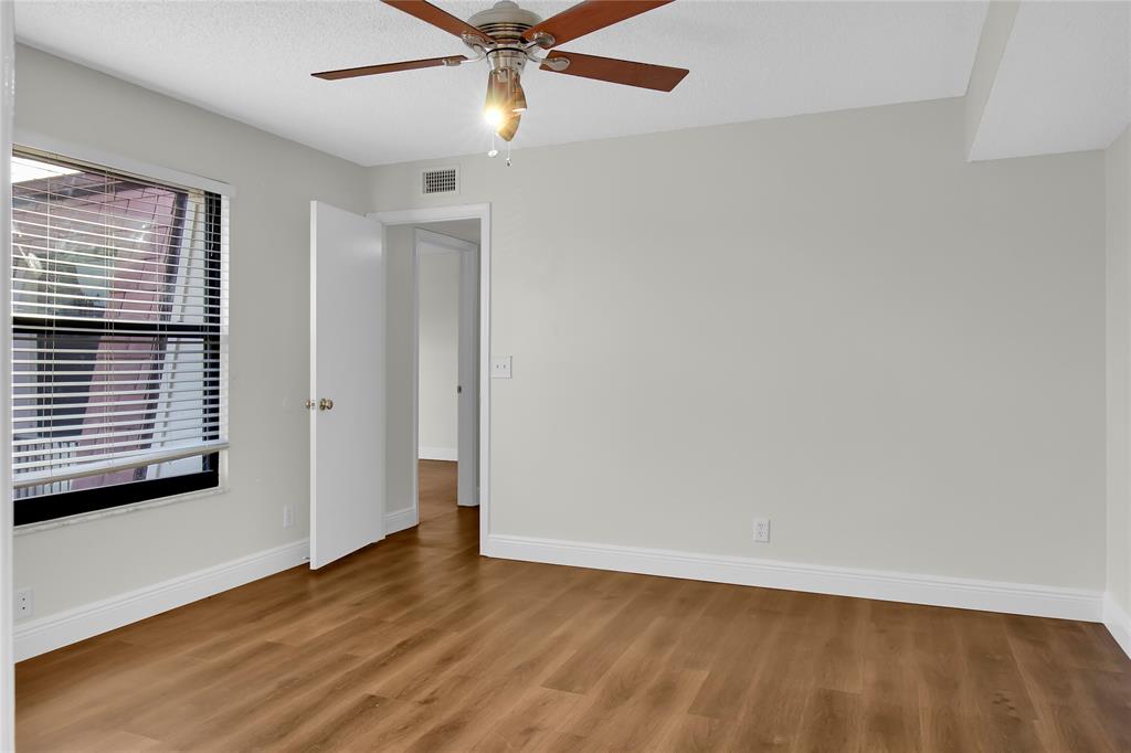 7801 Courtyard Run West Boca Raton, FL 33433 - Photo 20 of 31 an empty room with wooden floor fan and windows