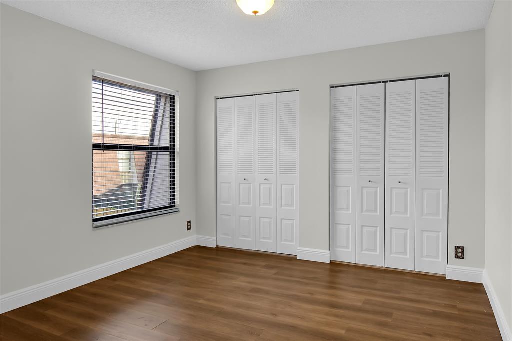 7801 Courtyard Run West Boca Raton, FL 33433 - Photo 22 of 31 a view of an empty room with wooden floor and a window
