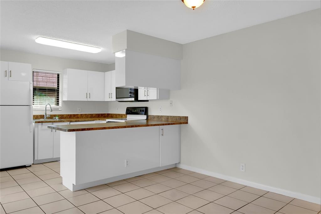 7801 Courtyard Run West Boca Raton, FL 33433 - Photo 10 of 31 a kitchen with granite countertop white cabinets and stainless steel appliances