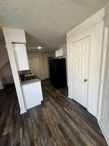 a view of kitchen with refrigerator and wooden floor