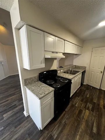 a kitchen with granite countertop a stove and a refrigerator