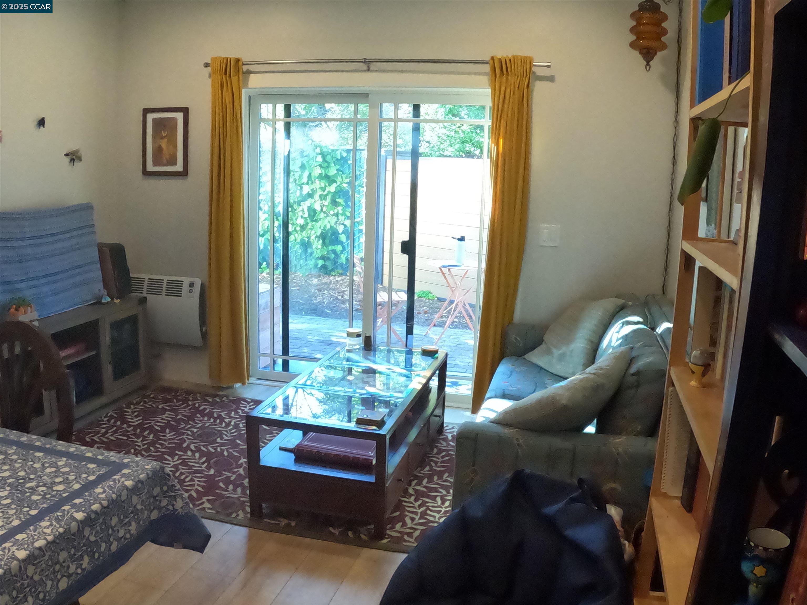 1329 Hopkins Street, Unit D Berkeley, CA 94702 - Photo 12 of 16 a living room with furniture and a floor to ceiling window