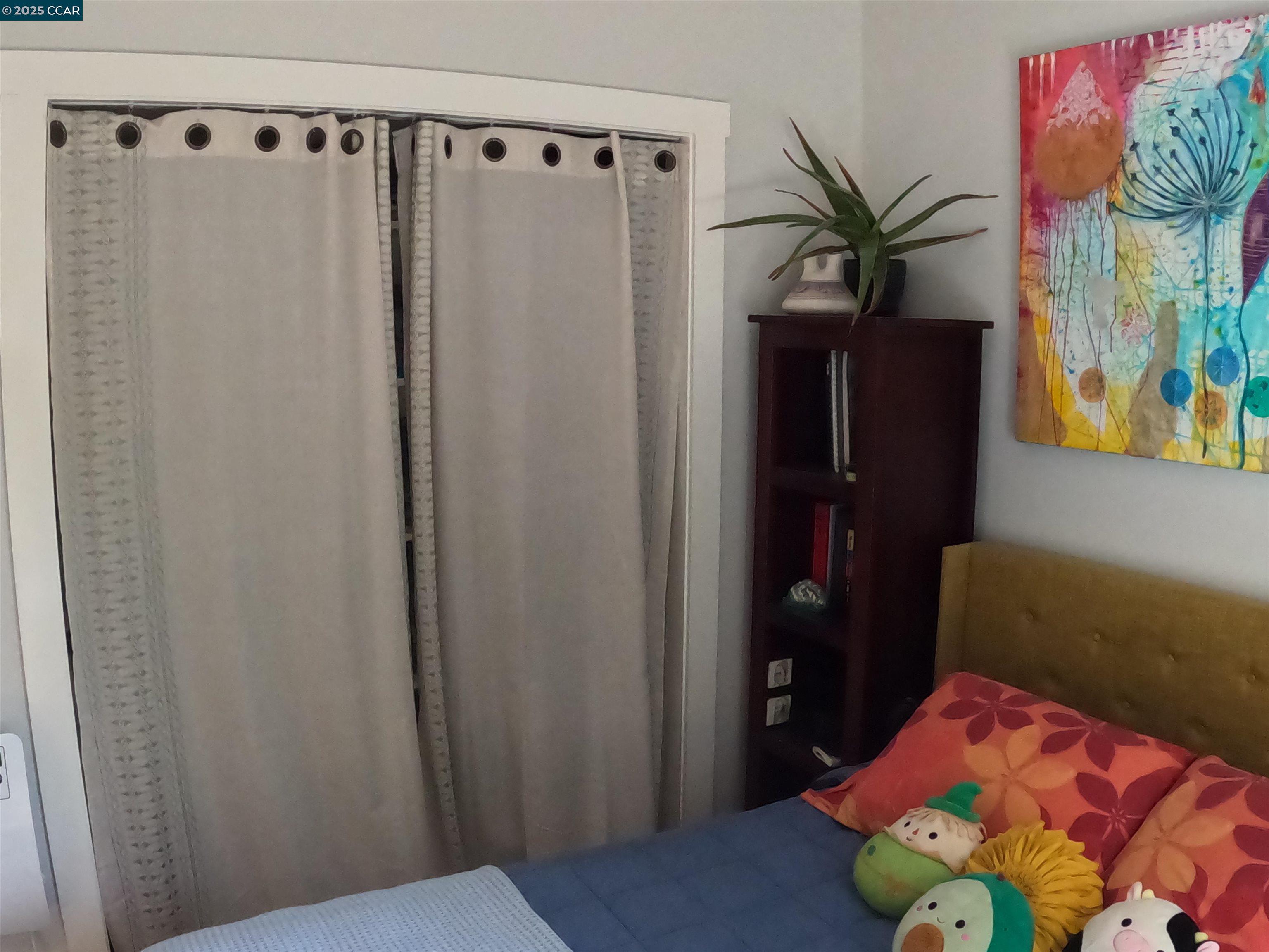 1329 Hopkins Street, Unit D Berkeley, CA 94702 - Photo 13 of 16 a bedroom with a bed and a mirror on the dresser
