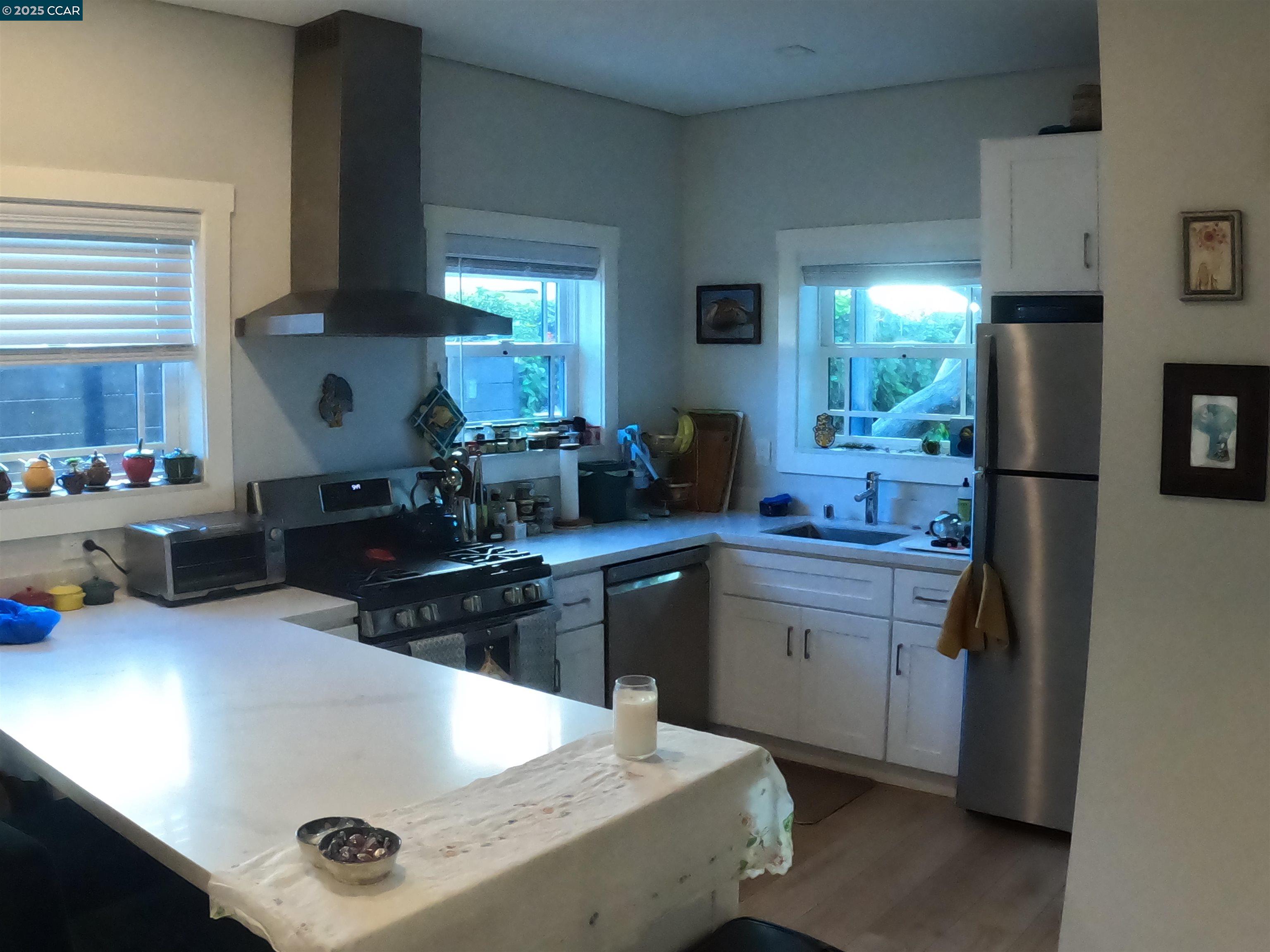 1329 Hopkins Street, Unit D Berkeley, CA 94702 - Photo 5 of 16 a kitchen with stainless steel appliances granite countertop a sink dishwasher stove and refrigerator