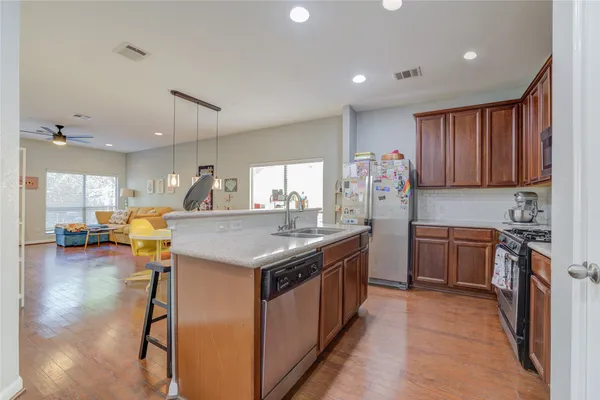 a kitchen with stainless steel appliances granite countertop a table chairs refrigerator sink and cabinets