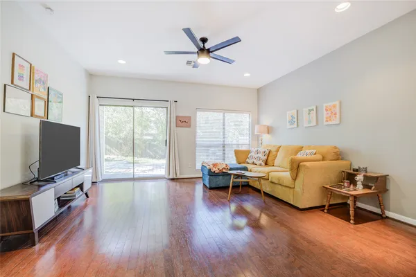 a living room with furniture and a flat screen tv with wooden floor