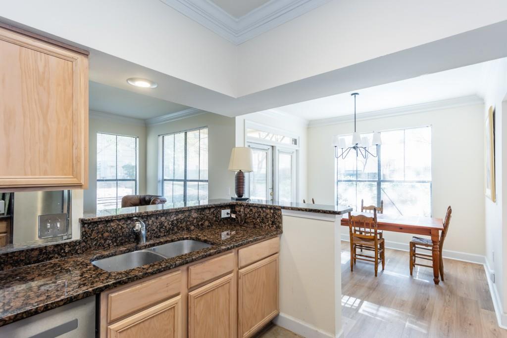3777 Peachtree Road Northeast, Unit 1007 Brookhaven, GA 30319 - Photo 12 of 39 a large kitchen with granite countertop a stove a sink a dining table and chairs