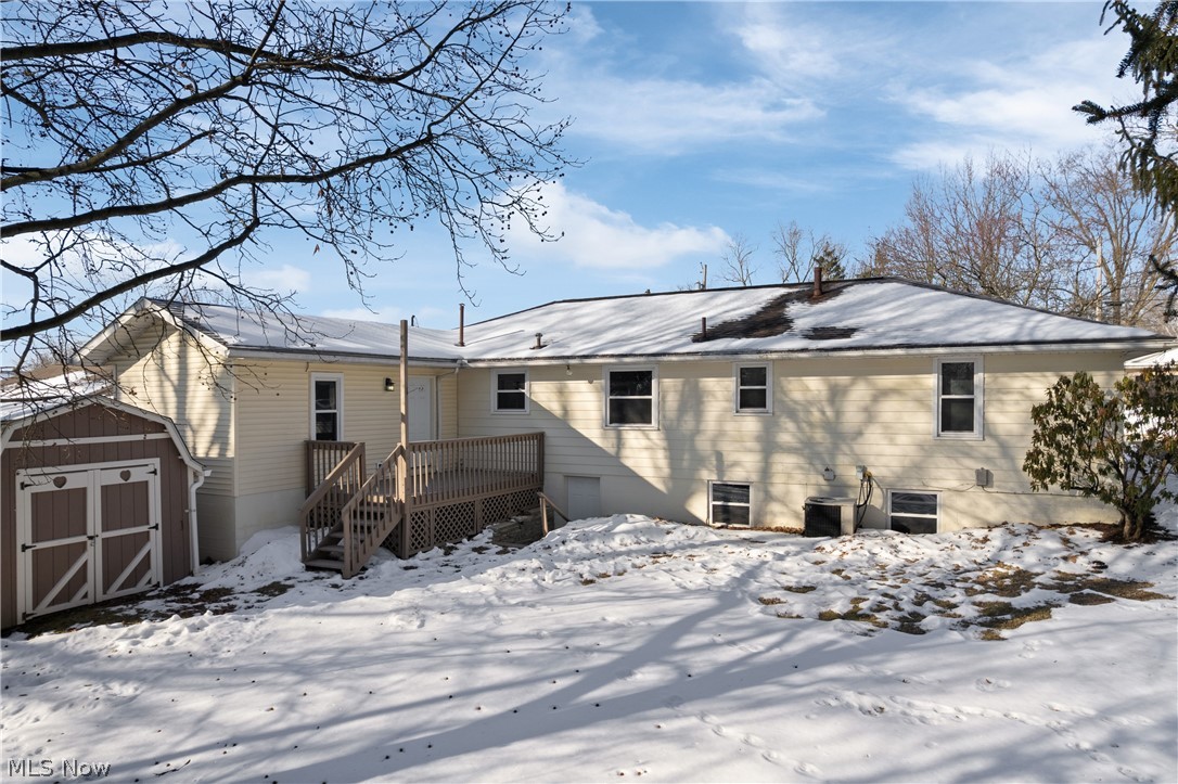 136 South Metzger Avenue Rittman, OH 44270 - Photo 20 of 33 Snow covered property featuring a storage shed and a wooden deck