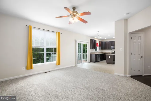 a view of an empty room with a window and cabinet