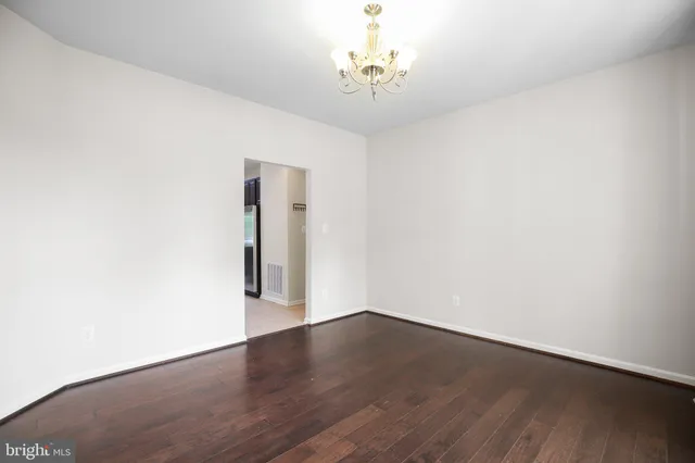 a view of a room with wooden floor and a chandelier