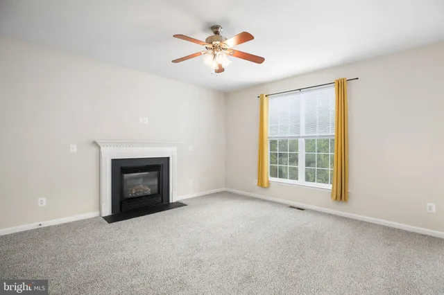 an empty room with fireplace and fan