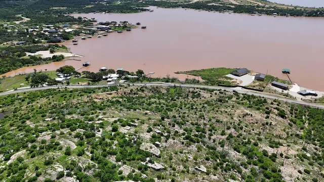 an aerial view of a house with a yard and lake view