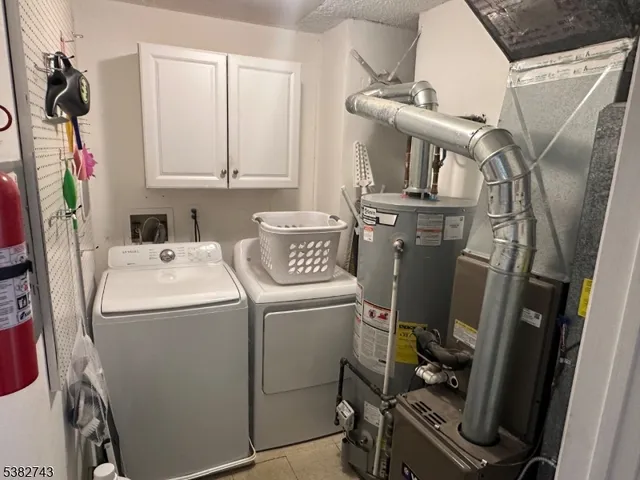 a utility room with dryer washer and stair