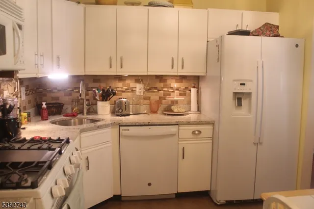 a kitchen with white cabinets and white appliances