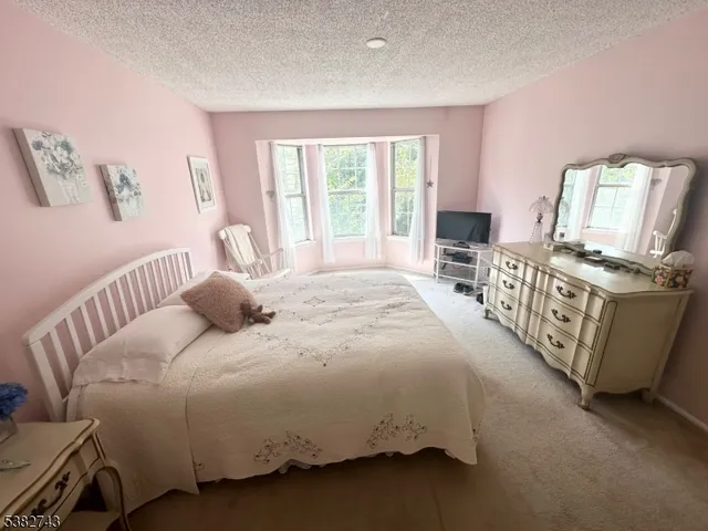 a bedroom with a bed a couch and dresser
