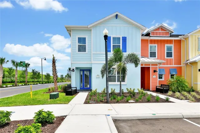 a front view of a house with a yard and potted plants