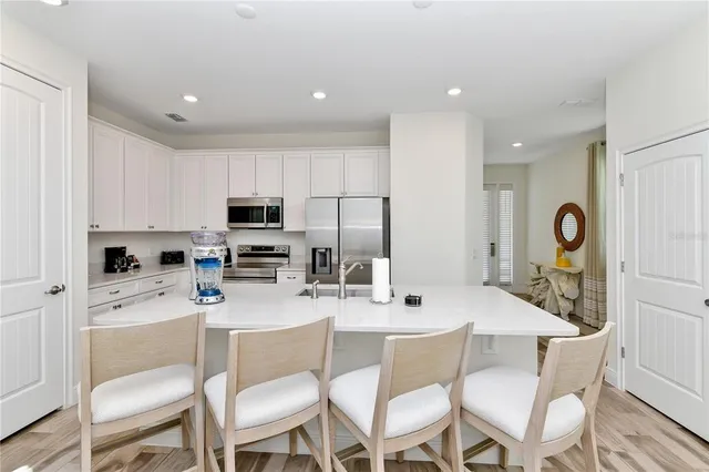 a kitchen with a dining table cabinets and stainless steel appliances