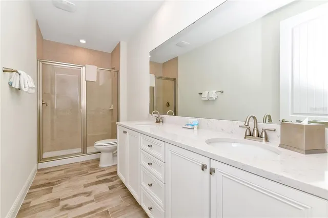 a bathroom with a double vanity sink toilet and shower