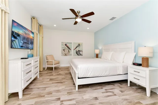 a bedroom with a large bed and a ceiling fan