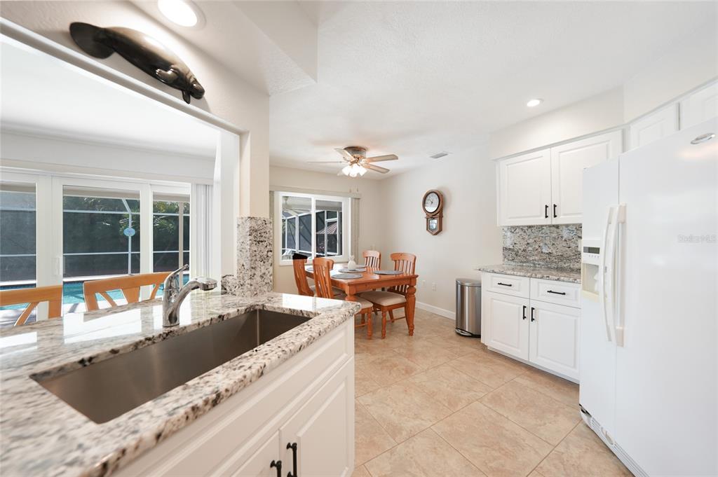 18097 Brazil Avenue Port Charlotte, FL 33948 - Photo 11 of 37 a large kitchen with granite countertop a sink and white cabinets